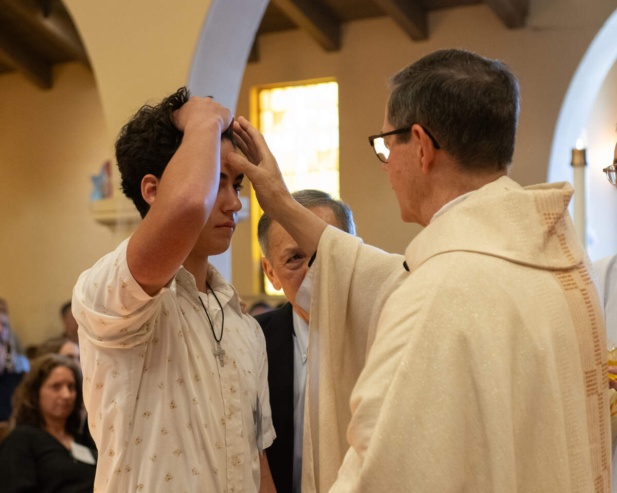 Teen receiving confirmation anointing